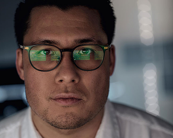 Portrait; Mann mit Brille in der sich User Interface spiegelt